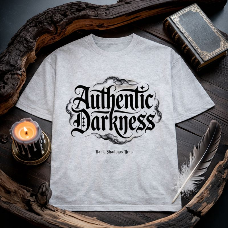 Dark Shadows Arts Premium Oversized Shirt „Authentic Darkness“ mit gotischer Typografie auf grauem Shirt, stimmungsvolles Flatlay Mockup mit Kerze, Feder und Buch