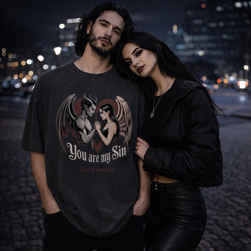 Dark Shadows Arts Premium Oversized Shirt in Schwarz mit Motiv „You Are My Sin“ – Engel und Dämon Paar vor rotem Herz, Dark Romantic Gothic Liebesdesign auf Oversized T-Shirt