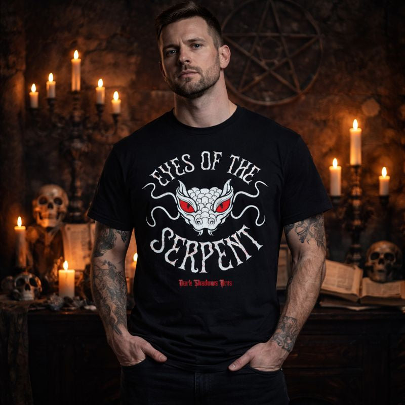 Männliches Model trägt Dark Shadows Arts Premium T-Shirt „Eyes of the Serpent“ mit okkultem Schlangenmotiv, schwarzes Gothic Shirt im mystischen Kerzen-Setting