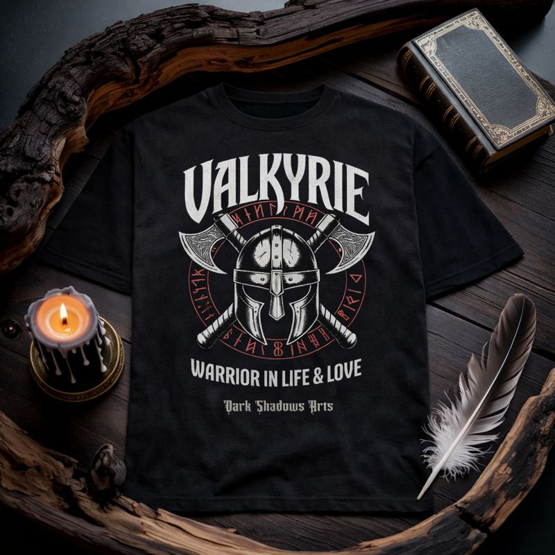 Dark Shadows Arts Premium Oversized T-Shirt „Valkyrie Oath – Warrior in Life & Love“ mit Wikingerhelm, gekreuzten Äxten und nordischem Runenkreis, fotografiert in einem düsteren Dark-Gothic Flatlay-Mockup mit Kerze, Feder und antikem Buch