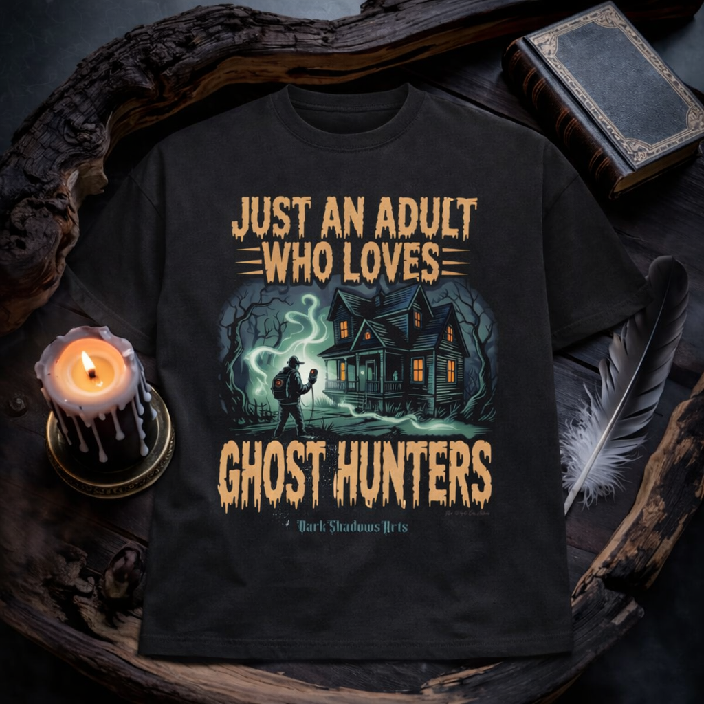 Just an Adult Who Loves Ghost Hunters Premium T-Shirt von Dark Shadows Arts im düsteren Flatlay Mockup mit Kerzenlicht, altem Buch und mystischer Atmosphäre – Haunted House und Ghost Hunter Motiv auf schwarzem Shirt